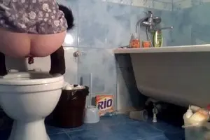 A girl with a black tail shitting into the toilet