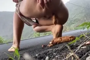 Woman pooping on the road somewhere in the mountains