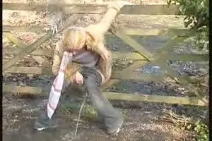 Woman pissing in a wooden fencethumb img