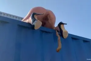 Naked blonde shit from the roof of a cargo container